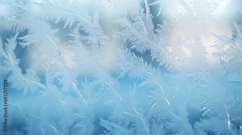 Beautiful frosty winter pattern on glass window with blurred background landscape behind