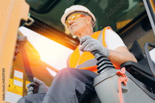 Close-up of builder hands operate crane or excavator at construction site.