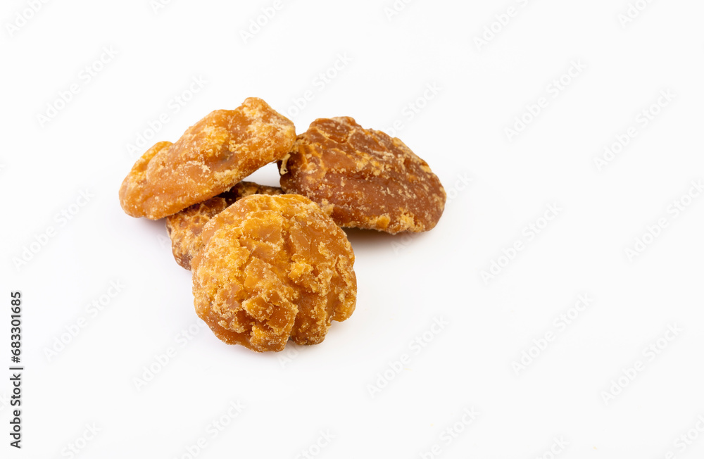 A close-up shot of jaggery neatly placed in a bowl against a clean white background A close-up shot of jaggery neatly placed in a bowl against a clean white background
