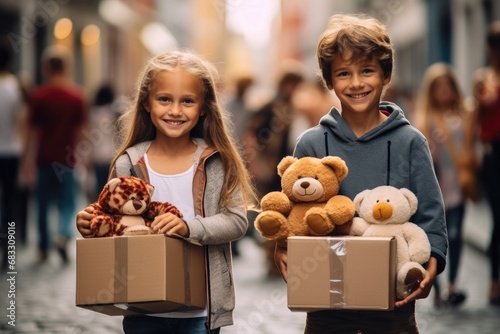 Boy and girl holding boxes with toys for donation in the street. photo