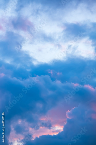 Blue morning sky with pink clouds. Sunrise clouds are in vanilla colours. Beauty in nature. Twilight time, golden hour. Details of evening sunset. Natural abstraction. Peace concept. Vertical view