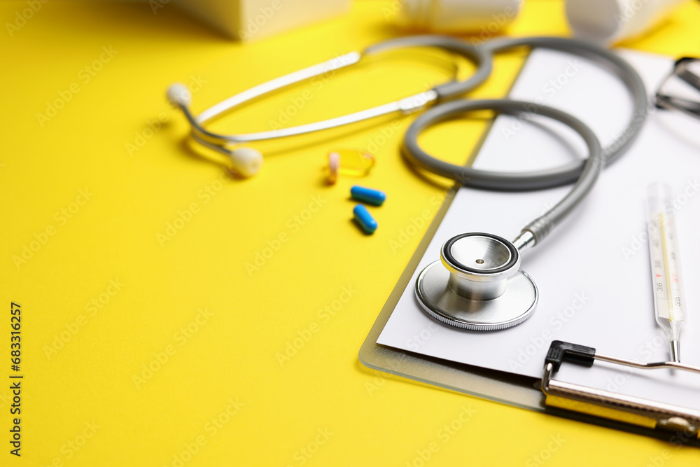 Doctor's desk top view. Set of different doctor accessories on a colored background. Pills, glasses, stethoscope and notebook. Doctor's desk top view. Set of different doctor accessories on a colored background. Pills, glasses, stethoscope and notebook.