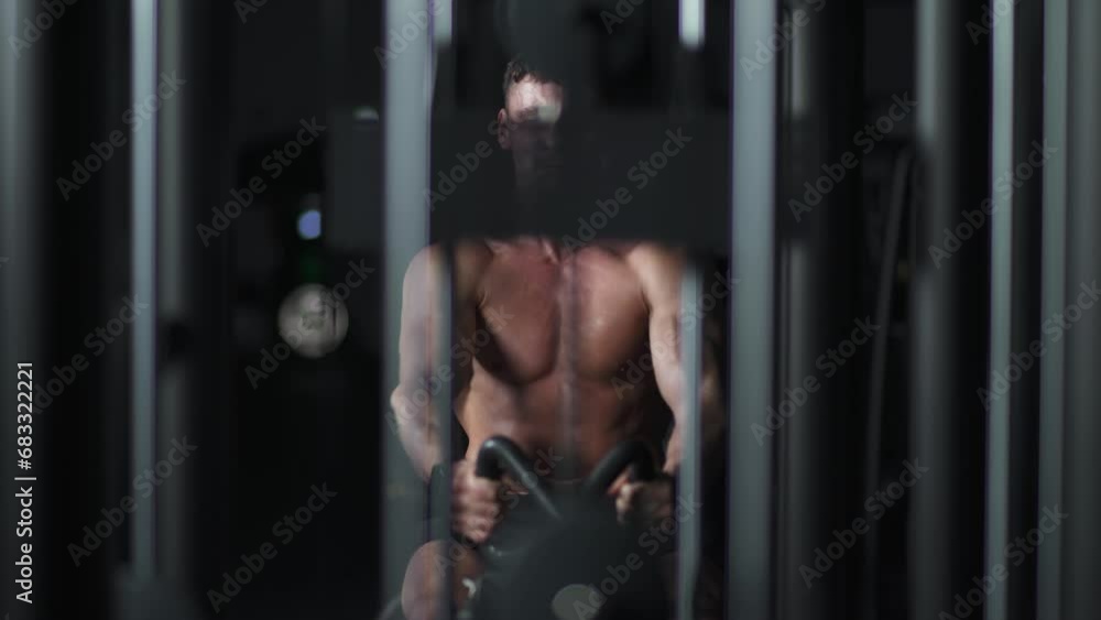 Athletic man in the Gym lifting blocks on rowing machine, training on block device and gym equipment, night time. Athletic man in the Gym lifting blocks on rowing machine, training on block device and gym equipment, night time.