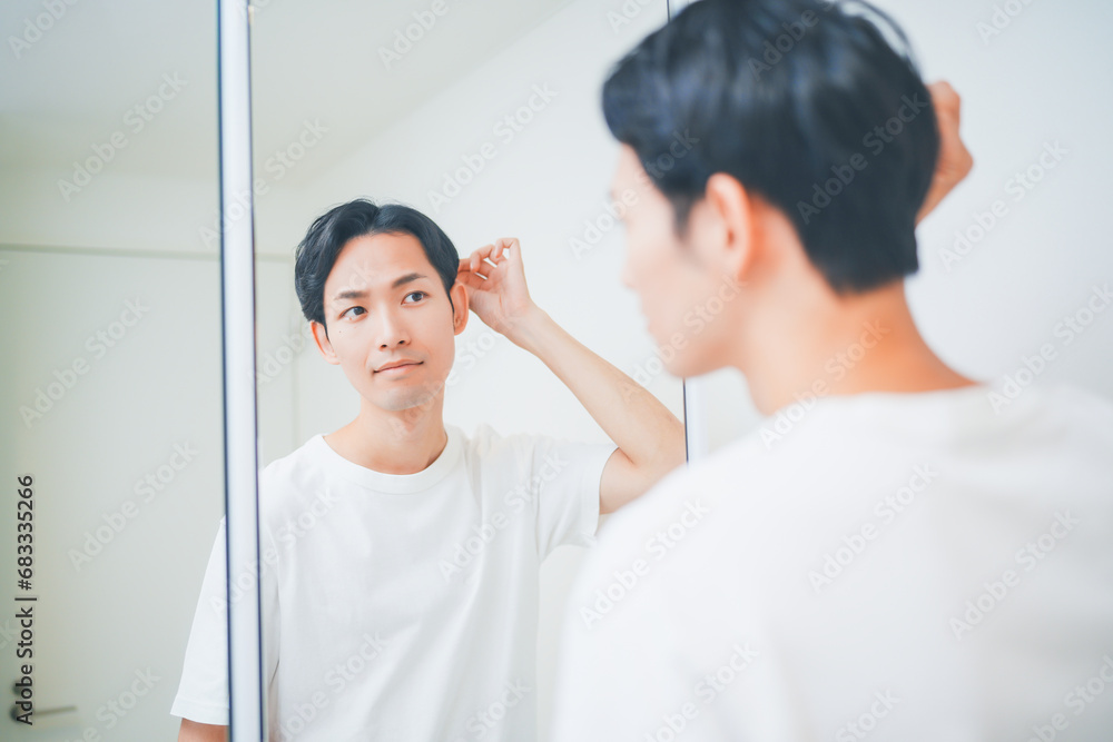 Fototapeta premium 洗面所でヘアセットをする男性