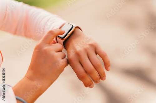 Close up shot of woman hands setting her pinky smart watch before running.