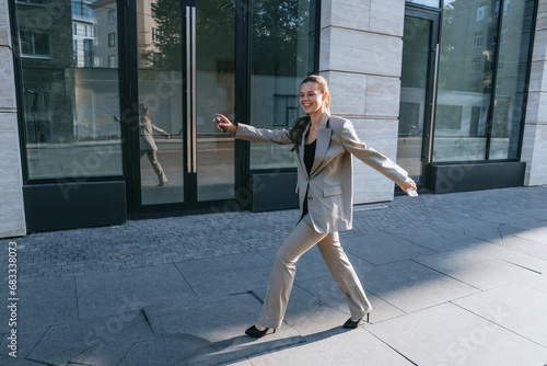 cheerful girl in a business suit, running down the street, rejoicing deal, holding the phone, smiling toothy, bright sunny day. concept of success business people The concept of success