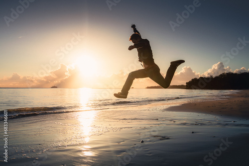 A silhouette of an athlete working out on a beach at sunset