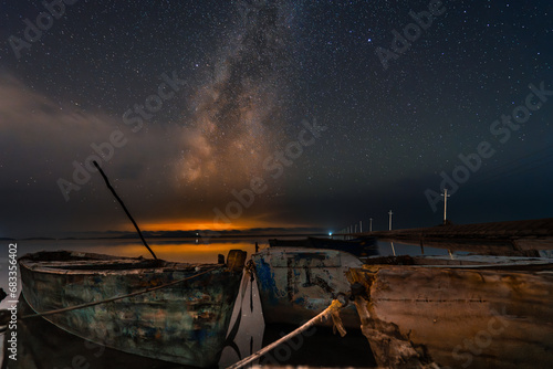 Old fishing boats on the albanian lagoon at night. Starry sky whith milkyway photo