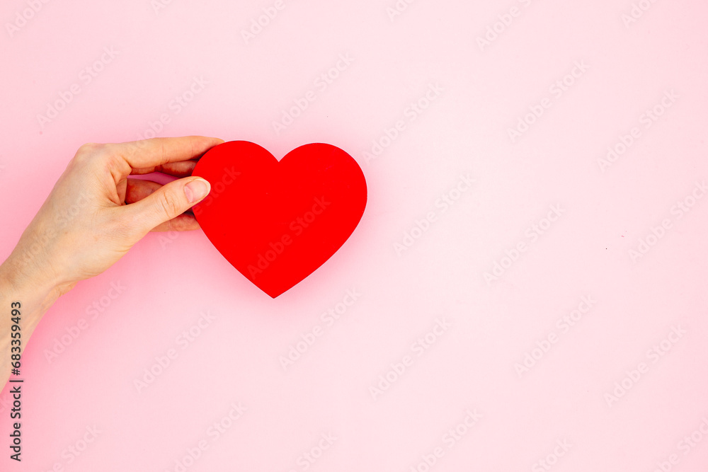 Medical insurance concept with red heart in female hands, top view