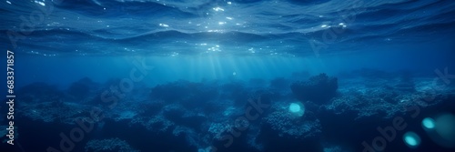 Blue Underwater Background with Piercing Sunlight and Subtle Bokeh Lights Banner. © Adam