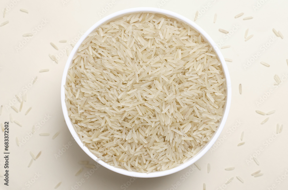 Raw basmati rice in a white bowl on a light background. Concept of Water-Conserving Products. Saving water. Vegetarian and vegan food. Healthy Eating. Horizontal orientation. Top view. Raw basmati rice in a white bowl on a light background. Concept of Water-Conserving Products. Saving water. Vegetarian and vegan food. Healthy Eating. Horizontal orientation. Top view.