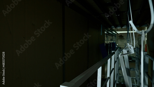 Corridor of modern industrial plant. Creative. Metal details hanging in narrow corridor in factory workshop.