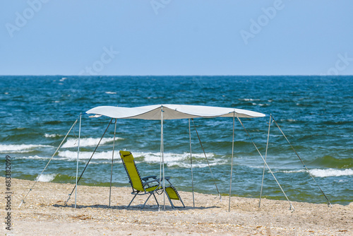 Beach chair and umbrella on the beach - shelter from the sun