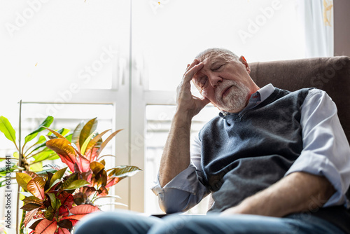 Senior man sleeping in an armchair at home
 photo