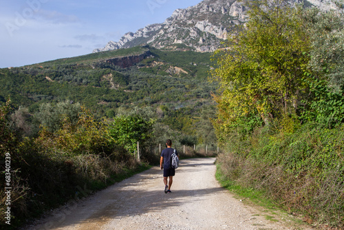 man walking along a mountain path
