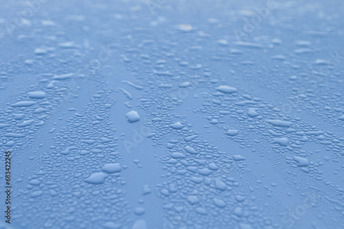 Raindrops on a surface with blue reflection