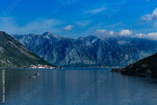 nature landscape of Boka Kotorska Bay in Montenegro, stunning green mountains, adriatic sea, stone houses, sailing boats, calm water with reflections