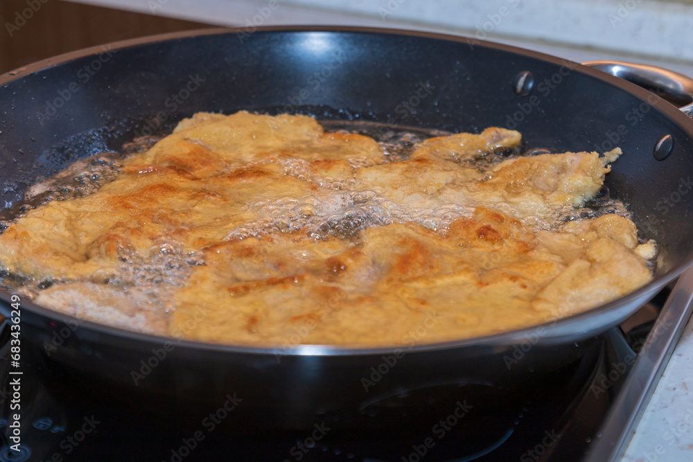 Fried meat in a triple package in a pan.