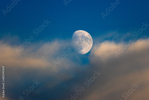 Shining moon in the sky between the clouds.