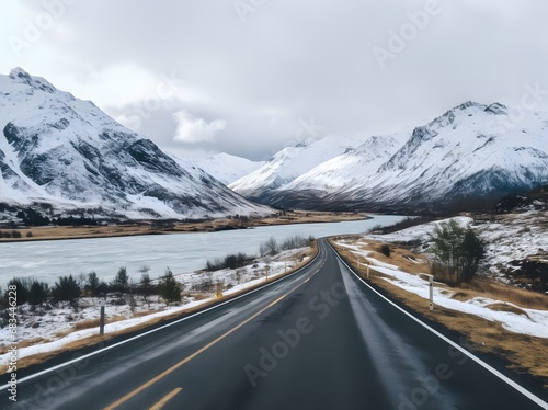 a narrow roadway going towards mountains covered with snow in in winters