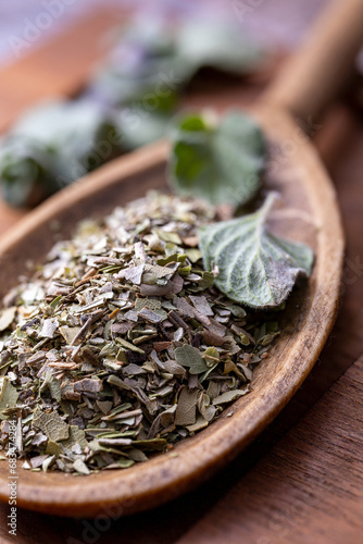 Chopped dried oregano put on the wooden spoon