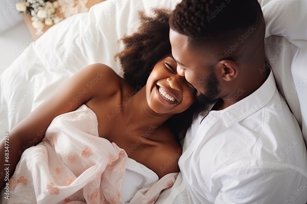 beautiful young black couple hugging and lying in bed