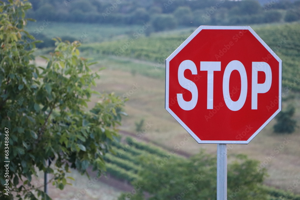 Stop road sign on the background of vineyards and farmland
