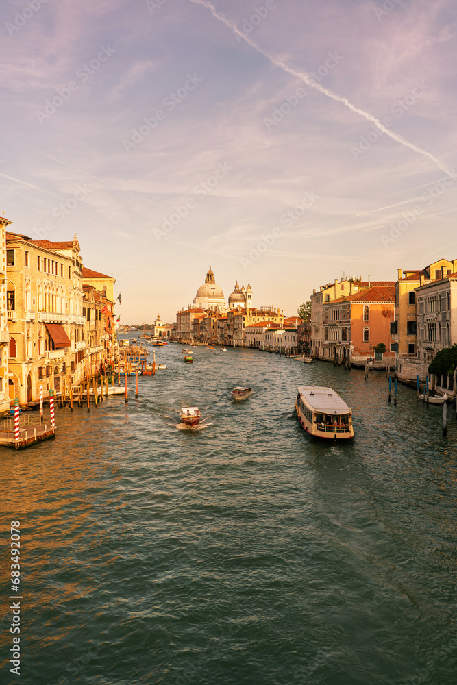 Obraz premium grand canal old city in venice italy with many boats, gondolas and italian palaces santa maria della salute basilica church in background