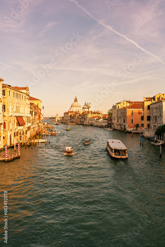 grand canal old city in venice italy with many boats, gondolas and italian palaces santa maria della salute basilica church in background © Blogtrip