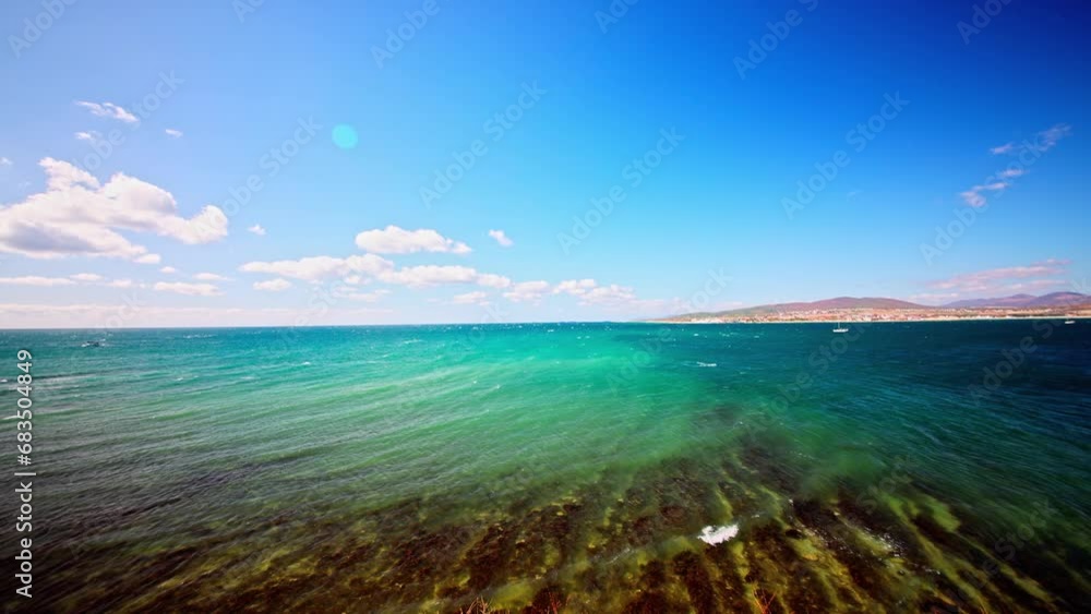 The sea in autumn in a strong wind. The sea is an amazing green color. Seaweed is visible near the shore. Small waves with foam. The sea in autumn in a strong wind. The sea is an amazing green color. Seaweed is visible near the shore. Small waves with foam.