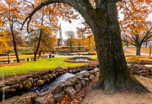 Small decorative cascade in old public park at golden autumn season