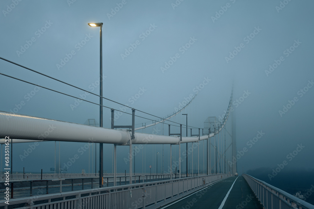 Forth Road Bridge covered in thick fog in the early morning and a burning lantern. Scotland, United Kingdom