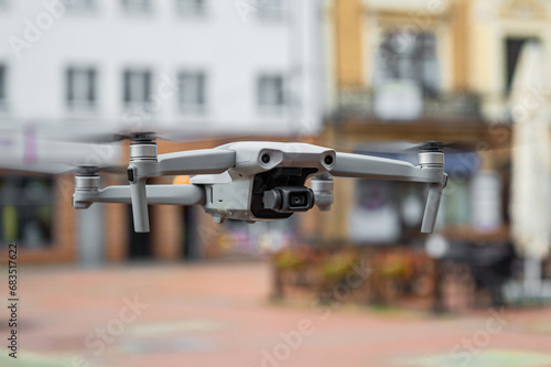 Drone with camera close up in blurred city background. 