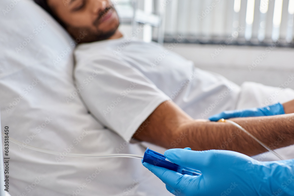 focus on hand of african american nurse setting drop counter with indian male patient on backdrop focus on hand of african american nurse setting drop counter with indian male patient on backdrop