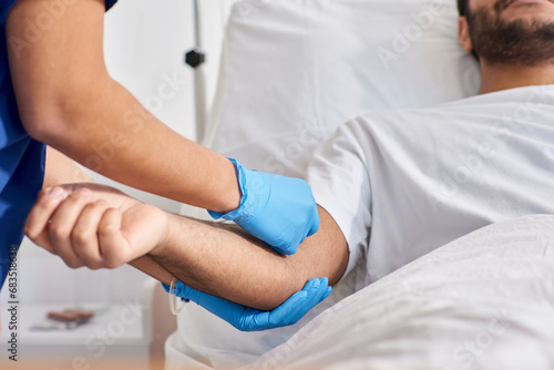 cropped view of african american nurse inserting catheter into arm of her indian patient, healthcare