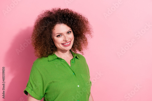 Photo of pretty charming young woman dressed green shirt smiling empty space isolated pink color background