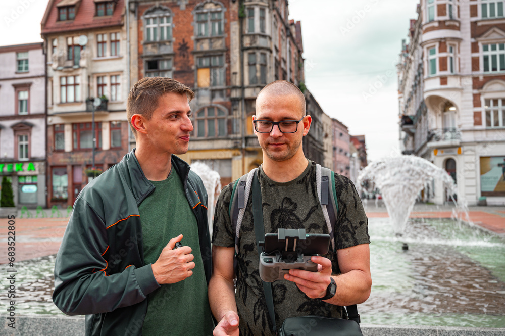 Two brothers operating a drone in the old city center.