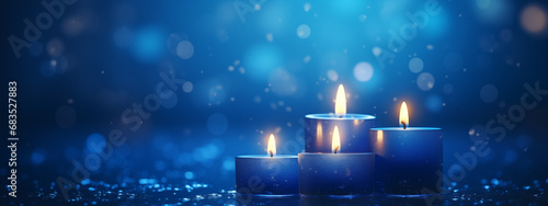 Flaming candles at night on dark blue background with lights. Candles in Christian church as catholic symbol. Abstract festive backdrop. Christmas eve or Chanukah banner with copy space photo