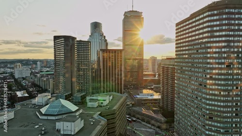 The sun is setting over a city with tall buildings photo