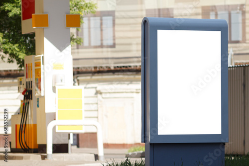 Vertical billboard next to a gas station. Mock-up.