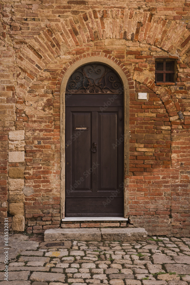 Ancient wooden door in brick wall.