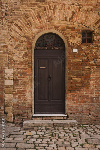 Ancient wooden door in brick wall.