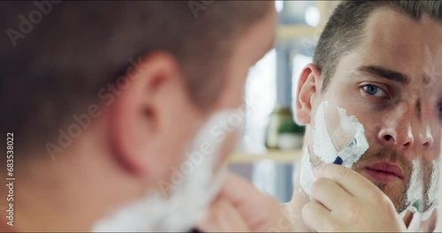 Morning, shaving cream and face of man in mirror with grooming, routine and razor for hair removal. Person, reflection and clean shave with care for beauty, skin and cosmetics in home bathroom photo