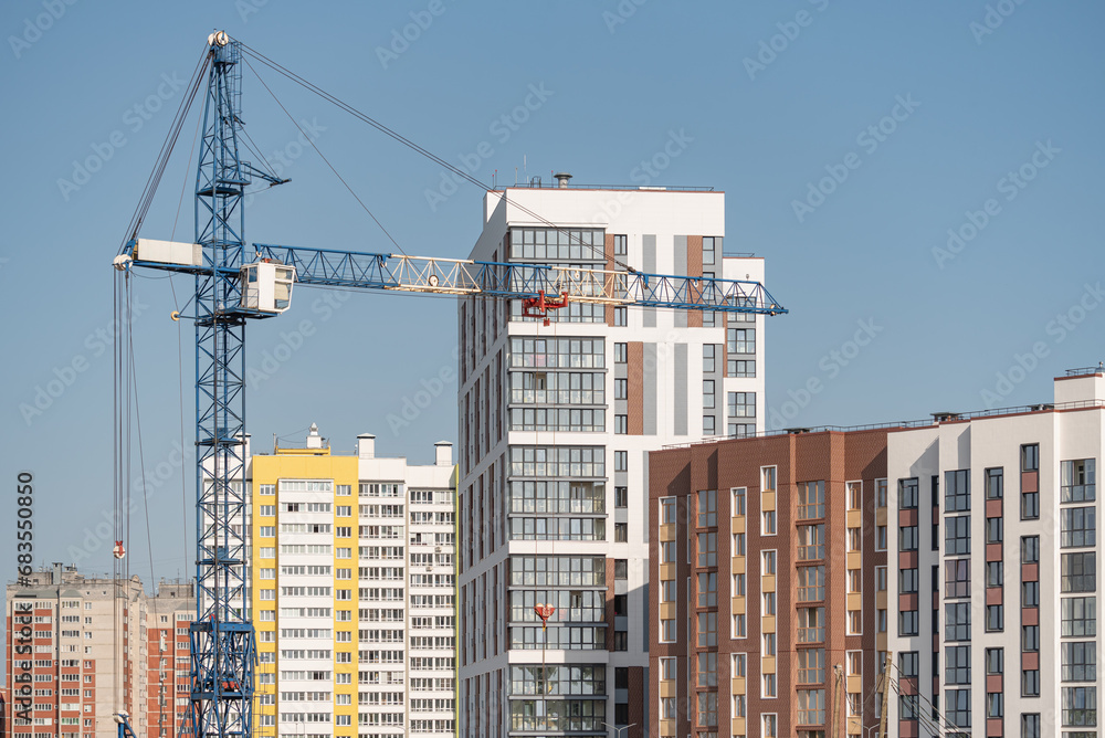 A construction site with a tower crane erecting a new house. A construction site with a tower crane erecting a new house.
