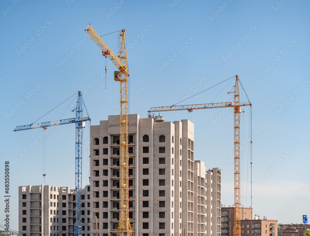 A construction site with a tower crane erecting a new house.