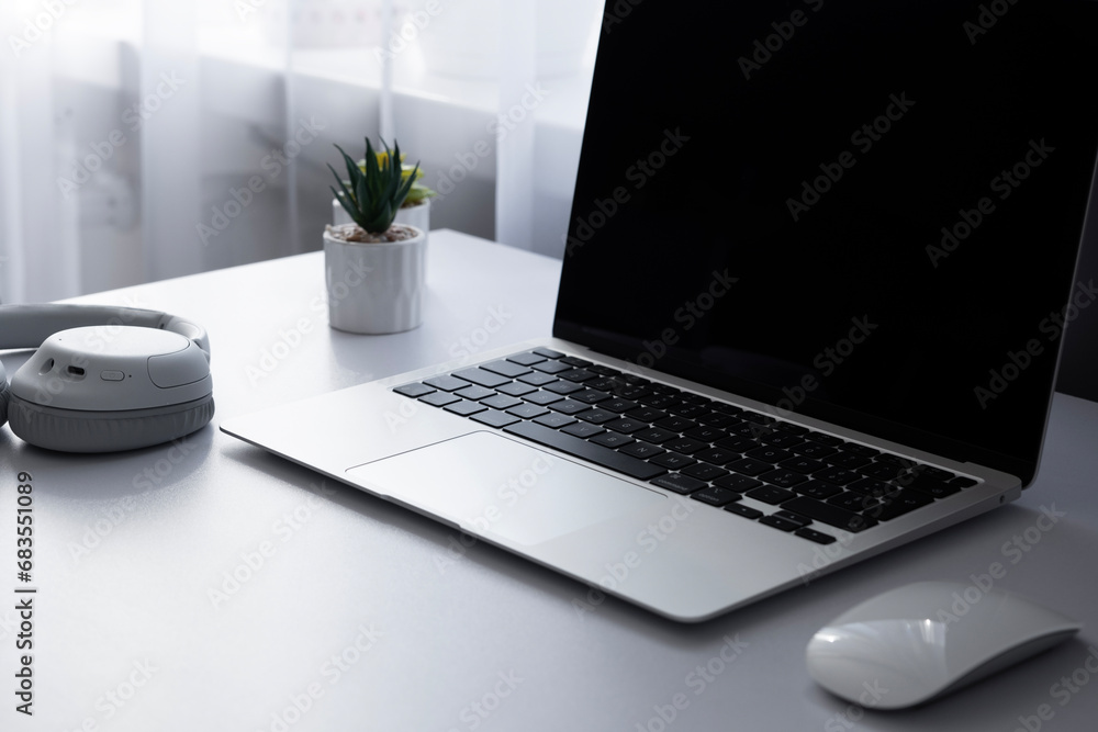 Laptop computer keyboard mouse and music earphones on a white table background Laptop computer keyboard mouse and music earphones on a white table background