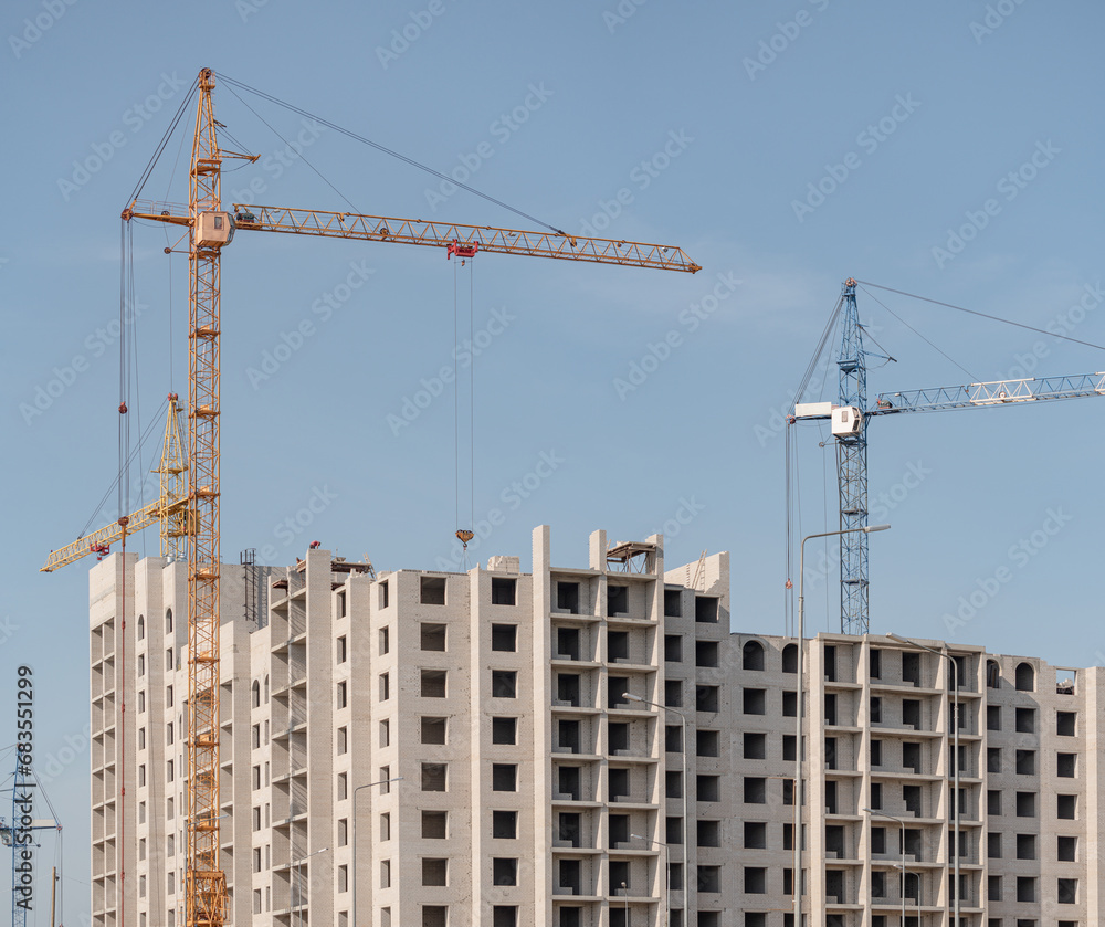 A construction site with a tower crane erecting a new house. A construction site with a tower crane erecting a new house.