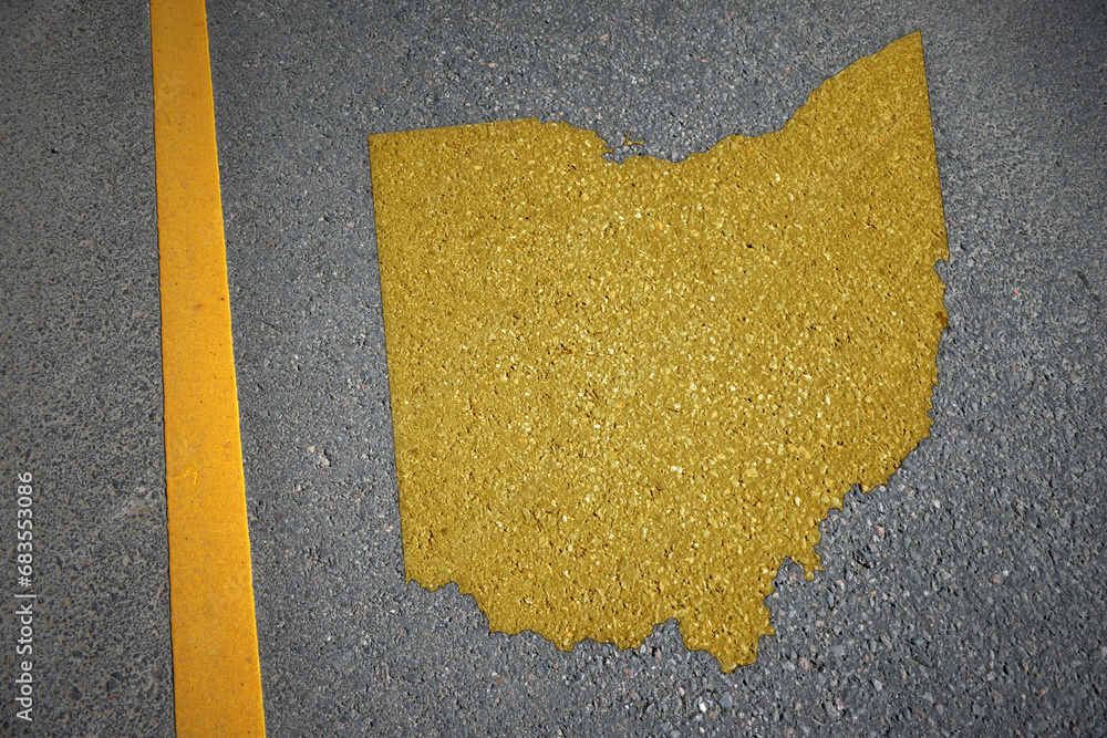 yellow map of ohio state on asphalt road near yellow line. - obrazy, fototapety, plakaty 
