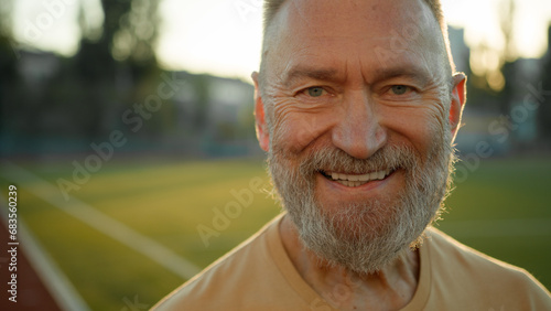 Close up portrait Caucasian cheerful man smiling laughing looking at camera morning city outdoors fun sport sportsman enjoyment lifestyle happy old male resting in staduim toothy dental smile sunshine