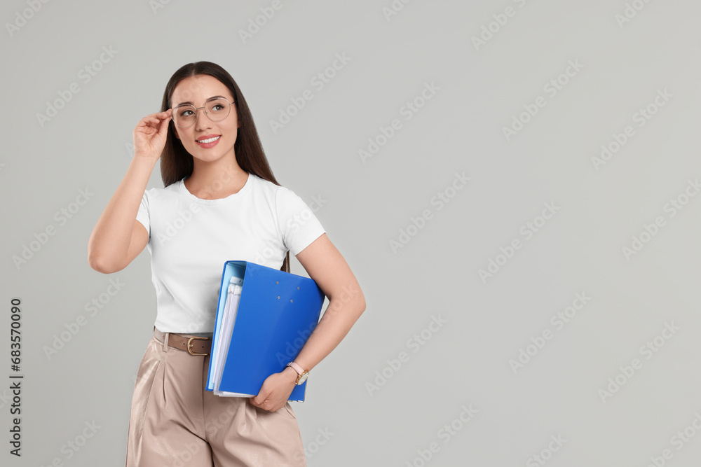 Happy woman with folder on light gray background, space for text Happy woman with folder on light gray background, space for text